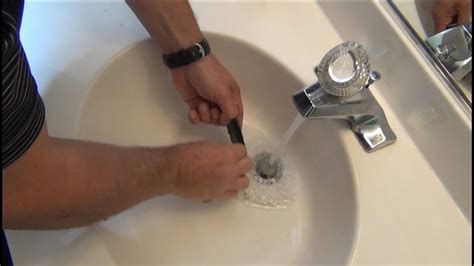 Insert a damp rag into the sink overflow holes to prevent water from traveling up through the overflow. Place a plunger into the sink and keep the water level above the cup of the plunger. Plunge the sink several times with a series of quick plunges to clear the clog from the sink. If the clog persists, remove the trap from the underside of the ...